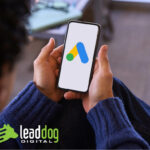 A person holds a mobile phone with the Google Ads logo on a digital screen - an illustration of search engine marketing and the importance of digital advertising.